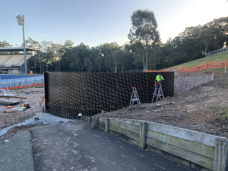 Worker on ladders at construction site.