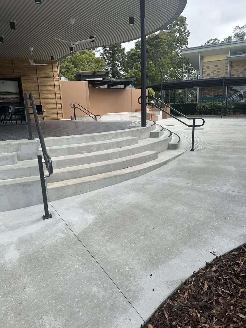 Gray concrete steps with metal railings and a ramp