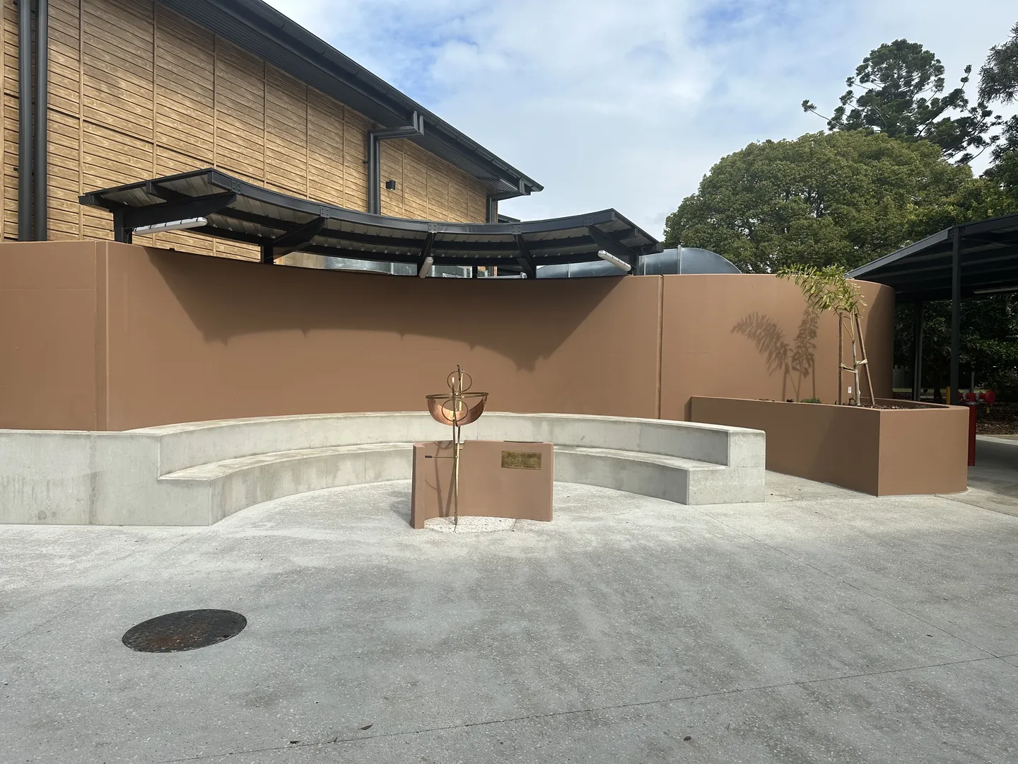 Outdoor seating with modern sculpture and trees