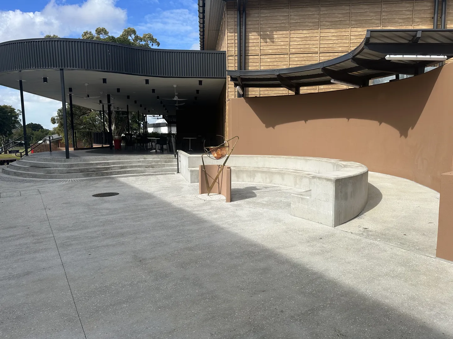 Modern outdoor seating area with curved concrete bench.