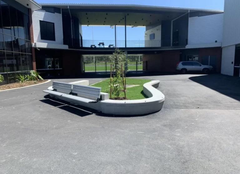 Outdoor courtyard with benches and a small tree.
