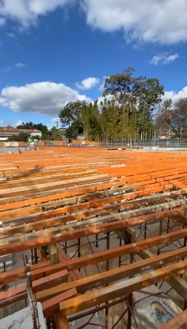Construction site with wooden beams and blue sky.