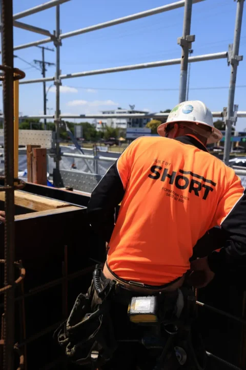 Construction worker on scaffolding at building site.